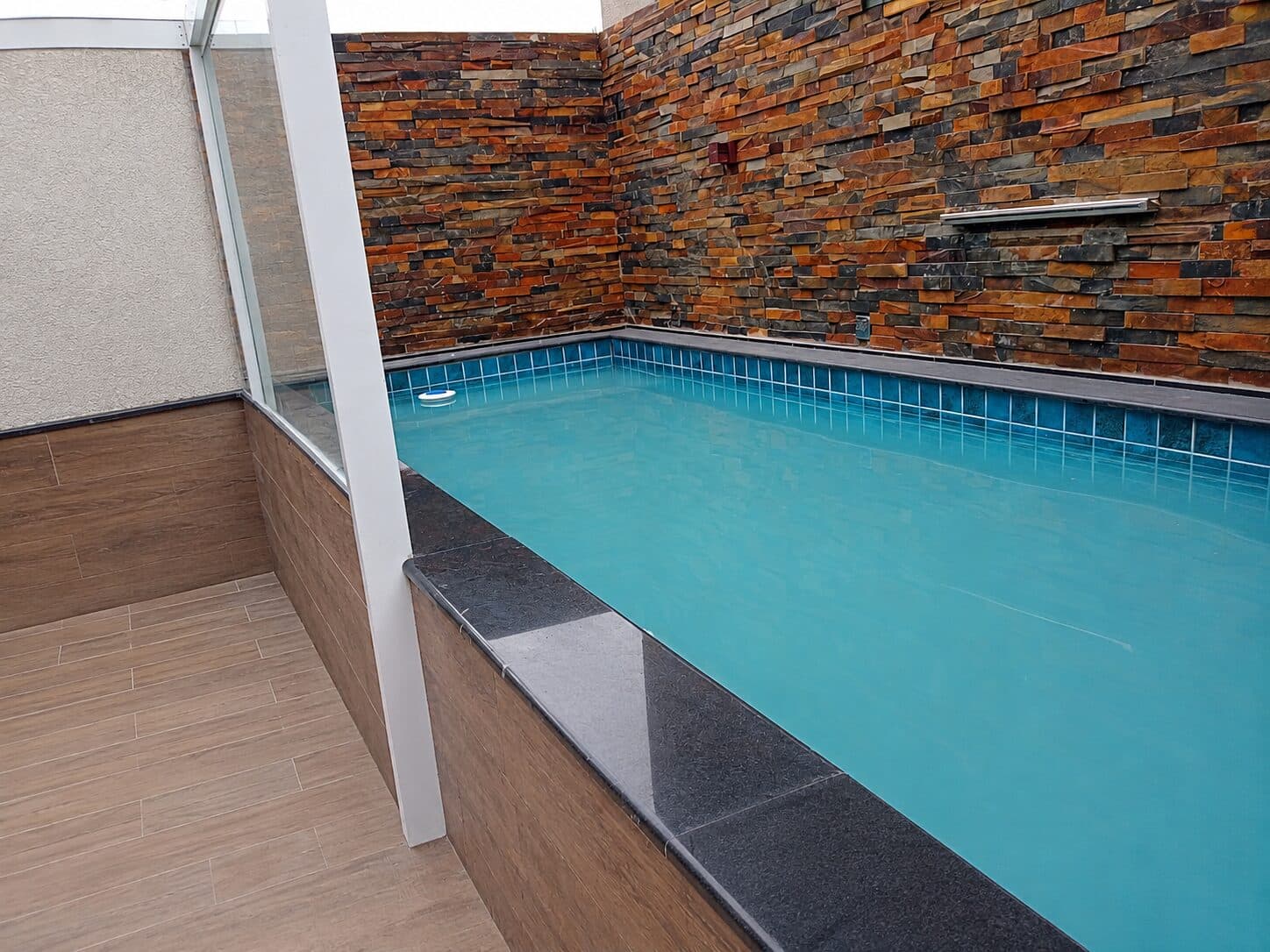 Borda de piscina com acabamento em pedra