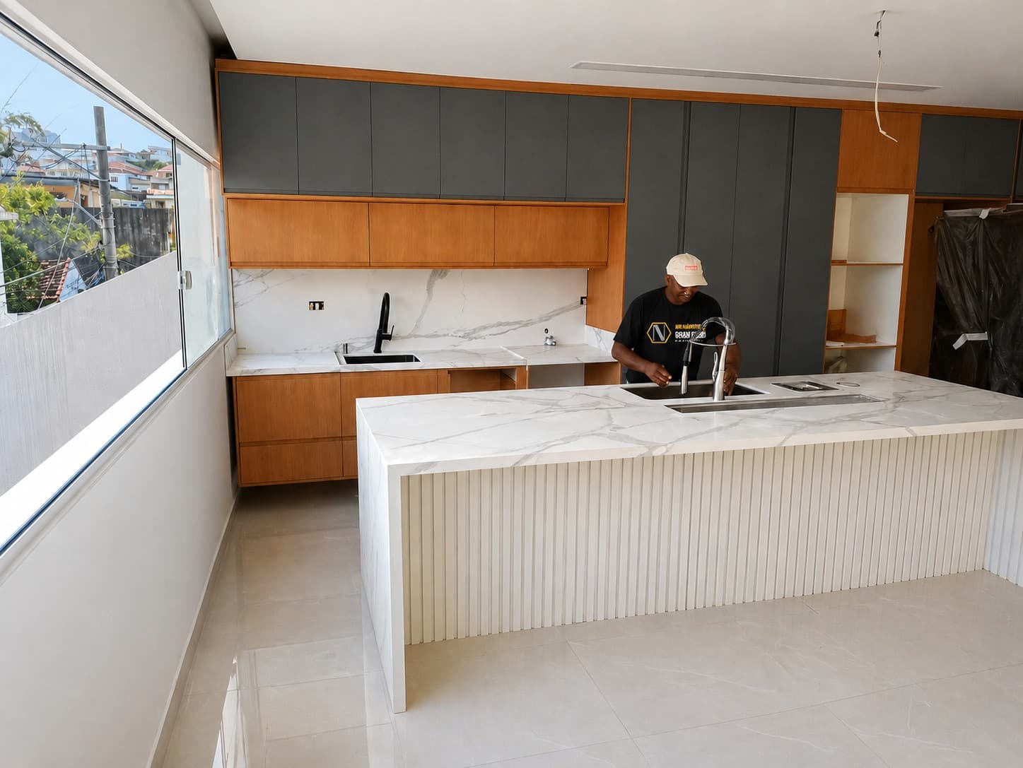 Profissional finalizando instalação de bancada de mármore em cozinha contemporânea